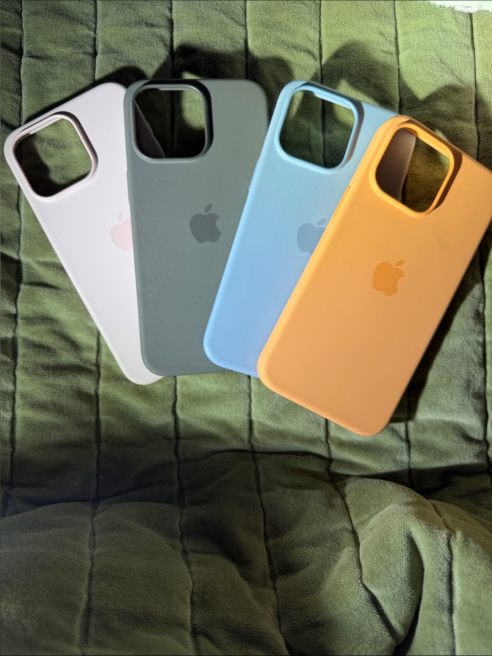 Apple Silicone iPhone Cases in light pink, grey, light blue, and light orange